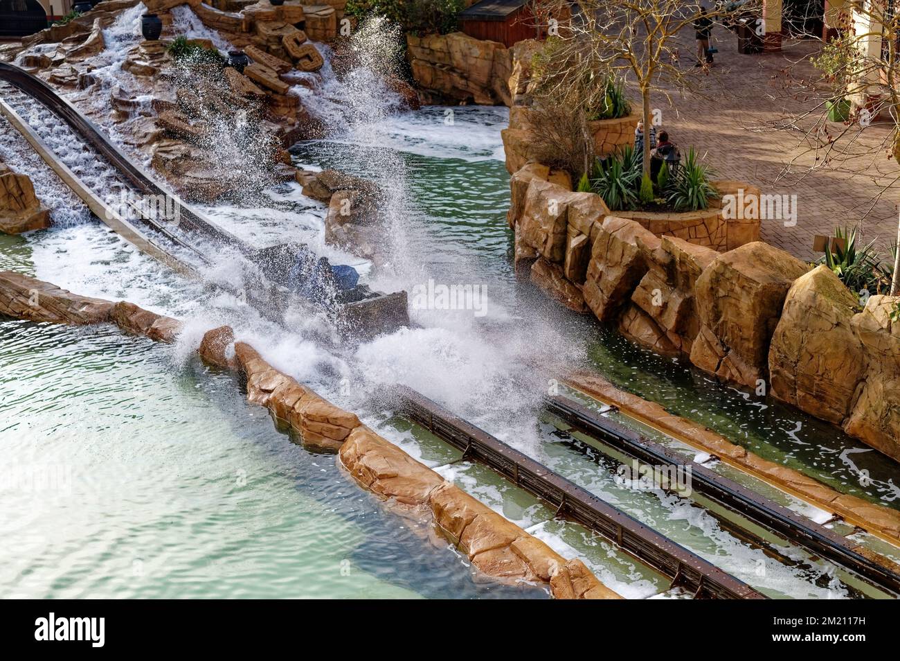 The people in a boat splashing into the water of a water slide ride in ...