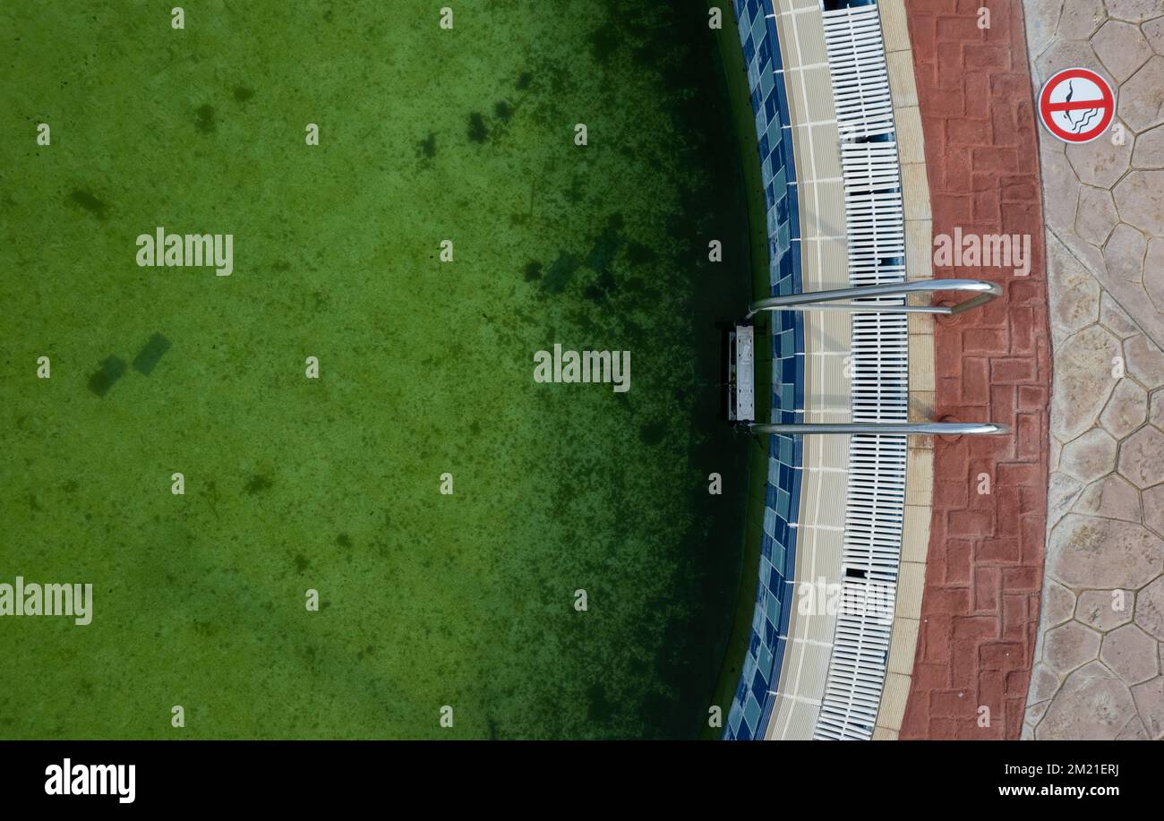 Drone point of view of a Deserted swimming pool. Poll lader green dirty water Stock Photo