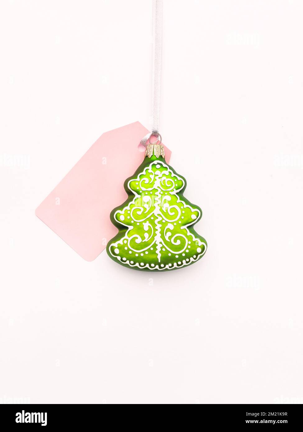 Decorative Christmas tree with pink price tag on white background