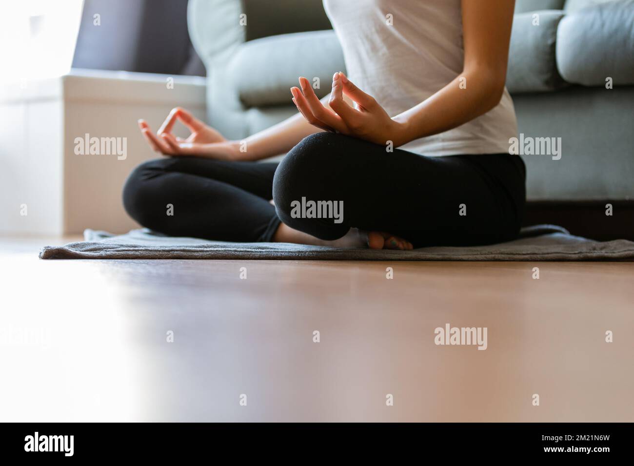 Crop unrecognizable young woman doing yoga at home Stock Photo