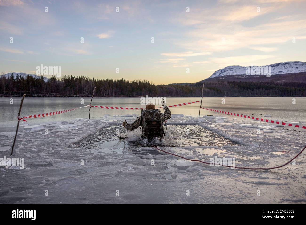 Setermoen, Norway. 25th Nov, 2022. A U.S. Marine with 2d Combat Engineer Battalion, 2d Marine Division, executes an arctic plunge during the NATO Cold Weather Instructor Course in Setermoen, Norway, November. 25, 2022. NCWIC is a course designed to develop Marines and other service members to be instructors of cold weather survival training in preparation for future deployments. Credit: U.S. Marines/ZUMA Press Wire Service/ZUMAPRESS.com/Alamy Live News Stock Photo