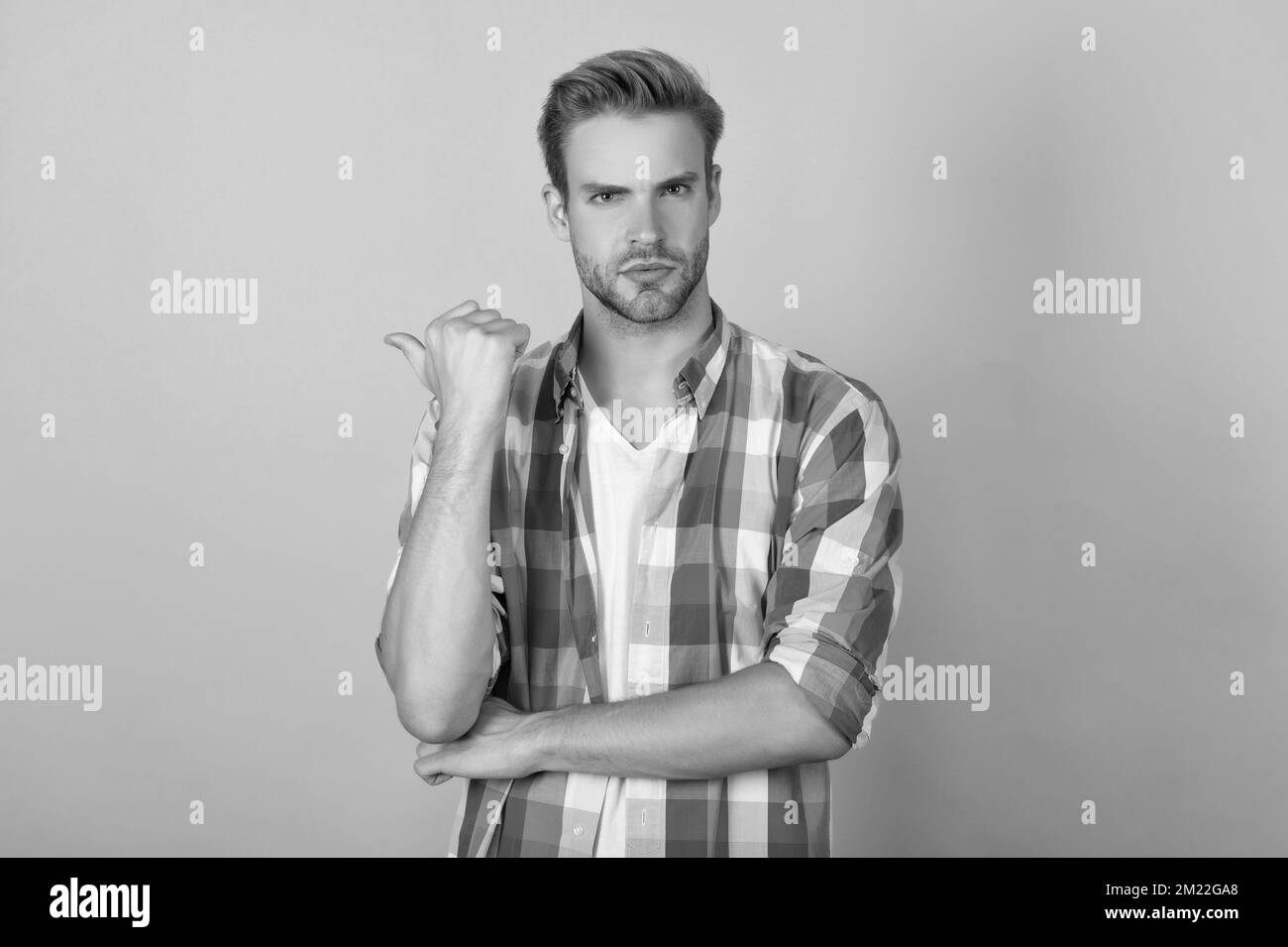 Pointing thumb for advertisiment. Serious guy point thumb yellow ...