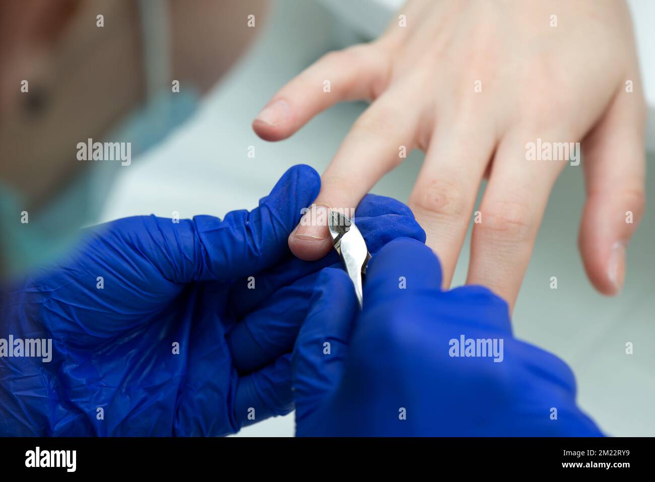 Woman hands in a nail salon receiving a classical cut manicure. Nail cuticle care. Manicure and