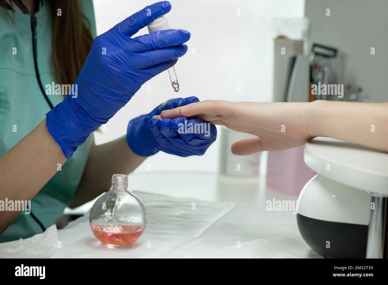 Woman hands in a nail salon receiving a classical manicure cuticle