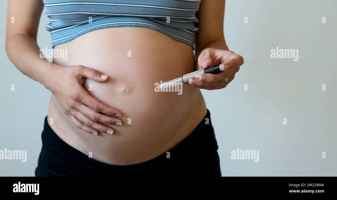 Pregnant woman makes injection of insulin in her belly. Diabetes and
