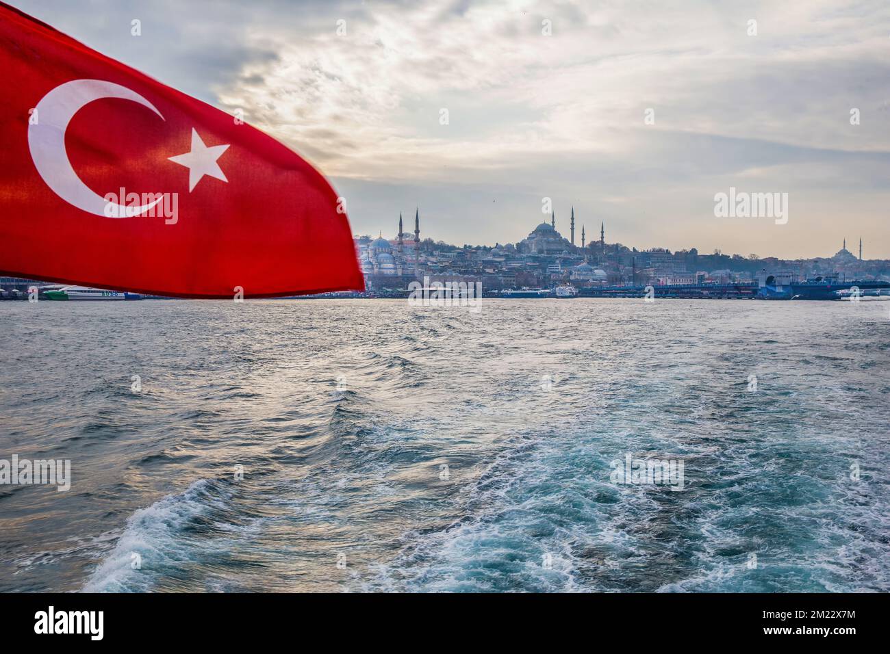 Suleymaniye Mosque nad red flag of Turkey on ferry Eminonu-Kadikoy. Galata bridge at right side Stock Photo