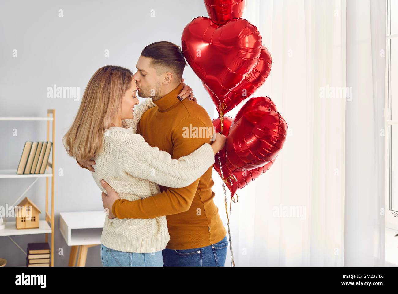 Beautiful couple hugs, kisses and enjoys spending time together while celebrating Valentine's Day. Stock Photo
