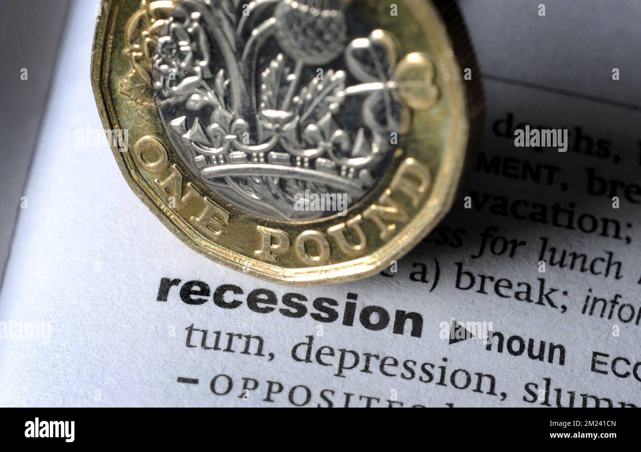 DICTIONARY DEFINITION OF WORD RECESSION WITH ONE POUND COIN RE COST OF LIVING CRISIS INFLATION MORTGAGES DOWNTURN ECONOMY ETC UK Stock Photo