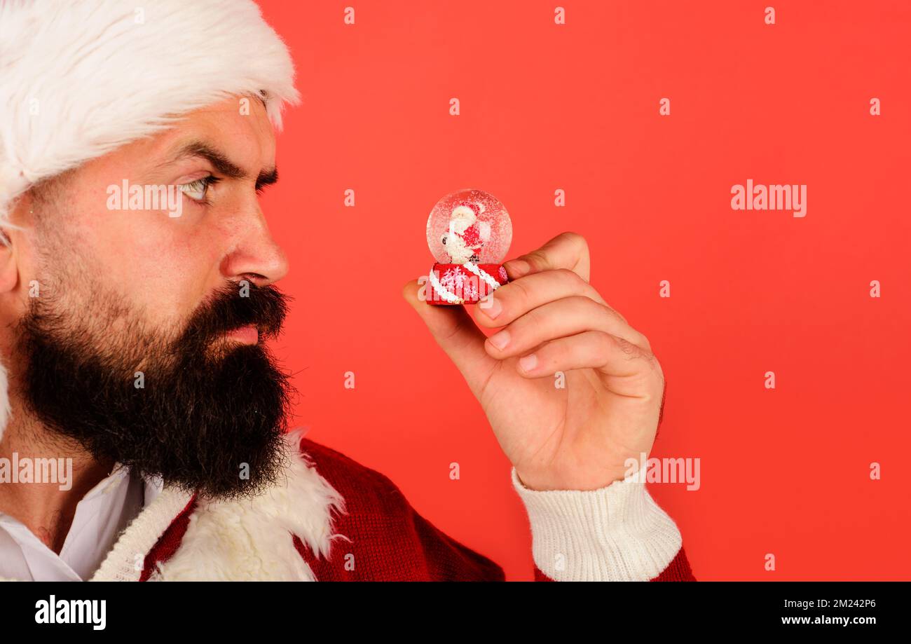 Santa Claus with christmas snow globe. Bearded man with small snowball. Decoration element. Stock Photo