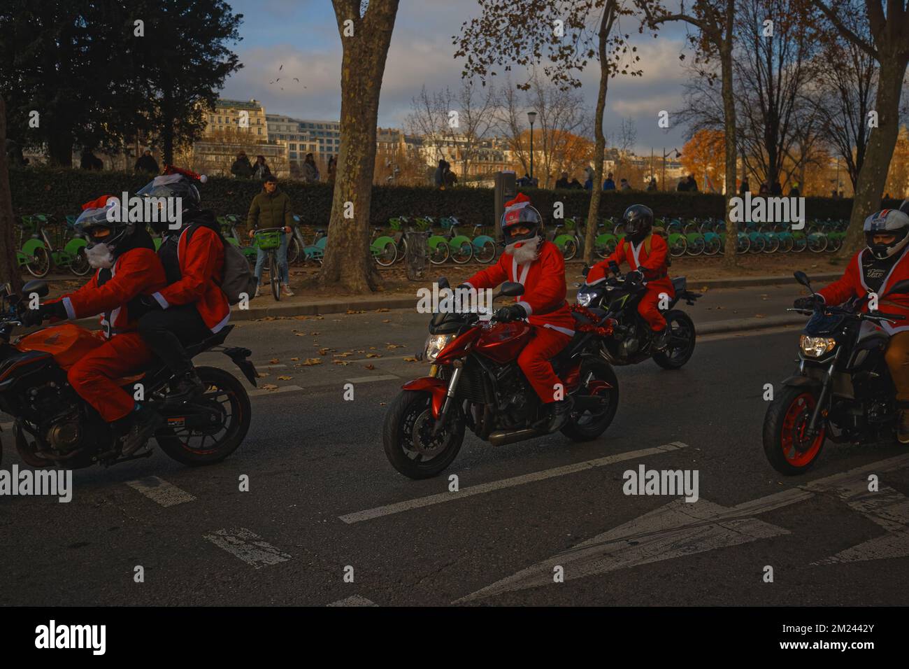 The group of men dressed in Santas on motorbikes seen in Paris near Eiffel tower. Stock Photo
