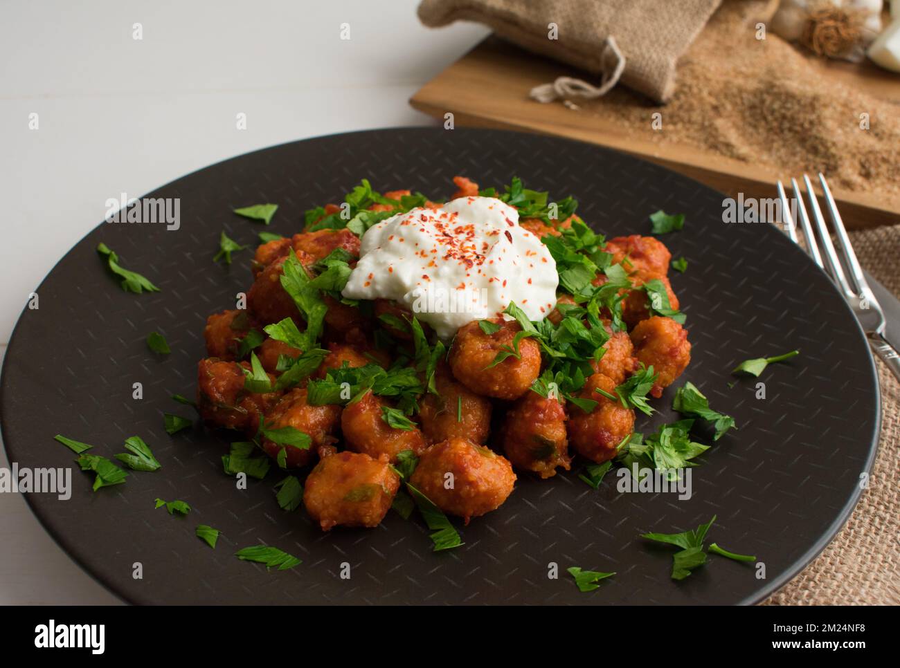 Traditional Turkish food “Fellah Kofte” , bulgur meatballs with tomato paste and garlic. Stock Photo