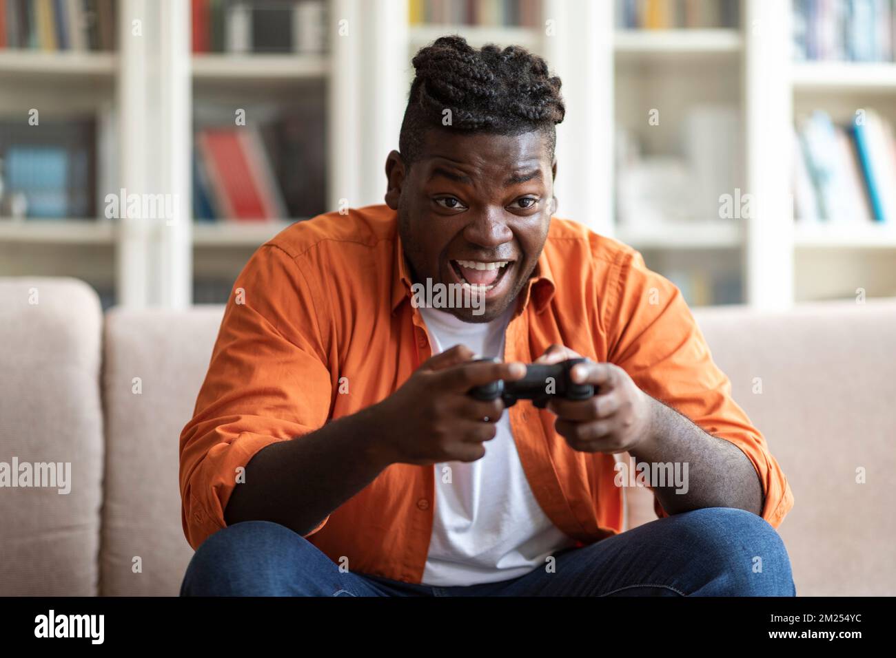 Handsome young black man playing video games at home Stock Photo