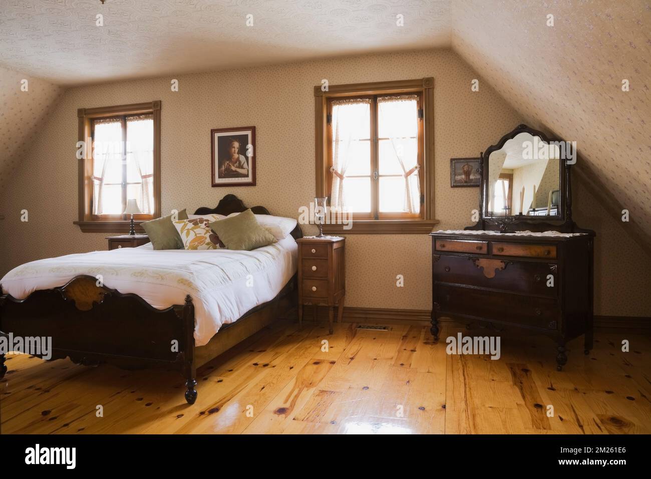 Double wood frame bed in master bedroom on upstairs floor inside old 1800s home. Stock Photo
