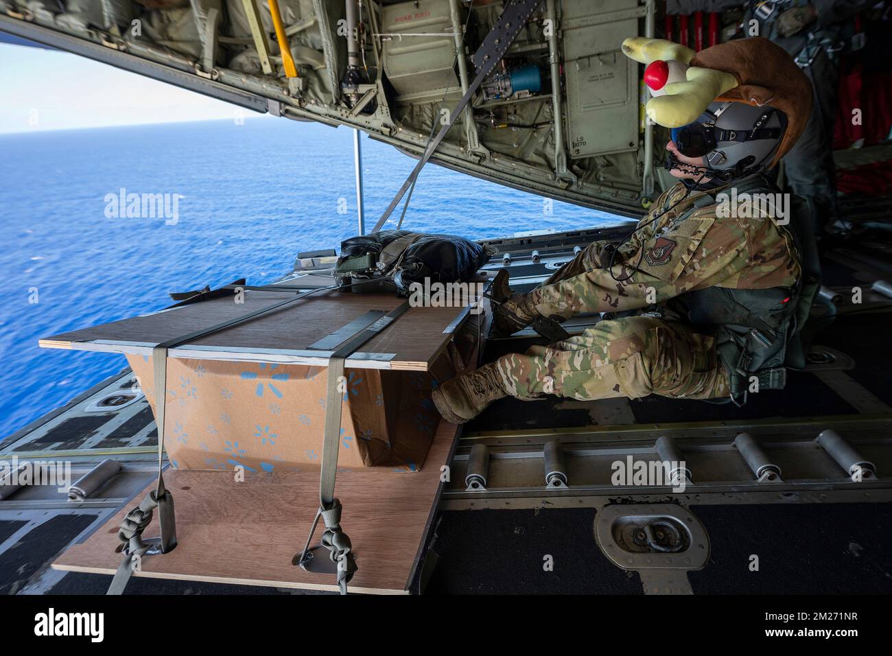 Guam, United States. 01 December, 2022. U.S. Air Force Airman Riley Henagar, 36th Expeditionary Airlift Squadron C-130J loadmaster, prepares a cargo bundle during Operation Christmas Drop 2022, December 1, 2022 near Guam. Operation Christmas Drop is the oldest humanitarian and disaster relief mission delivering 71,000 pounds of food, gifts, and supplies to assist remote island communities in the South Pacific.  Credit: Yasuo Osakabe/US Airforce Photo/Alamy Live News Stock Photo