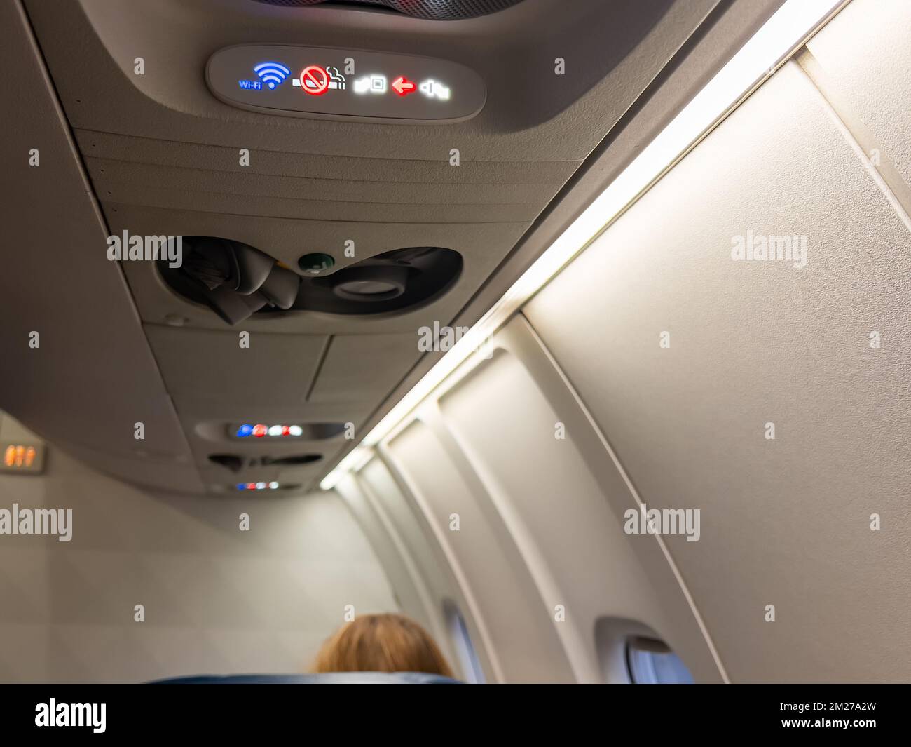 Indicator lights in airplane cabin for wi-fi, no smoking and seat belts. Stock Photo