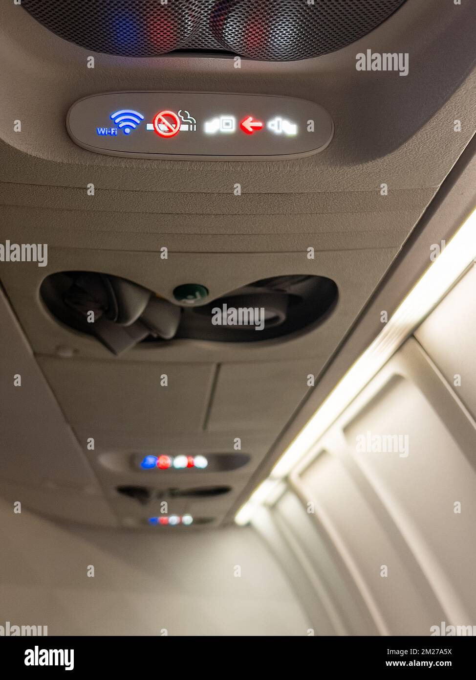 Indicator lights in airplane cabin for wi-fi, no smoking and seat belts. Stock Photo