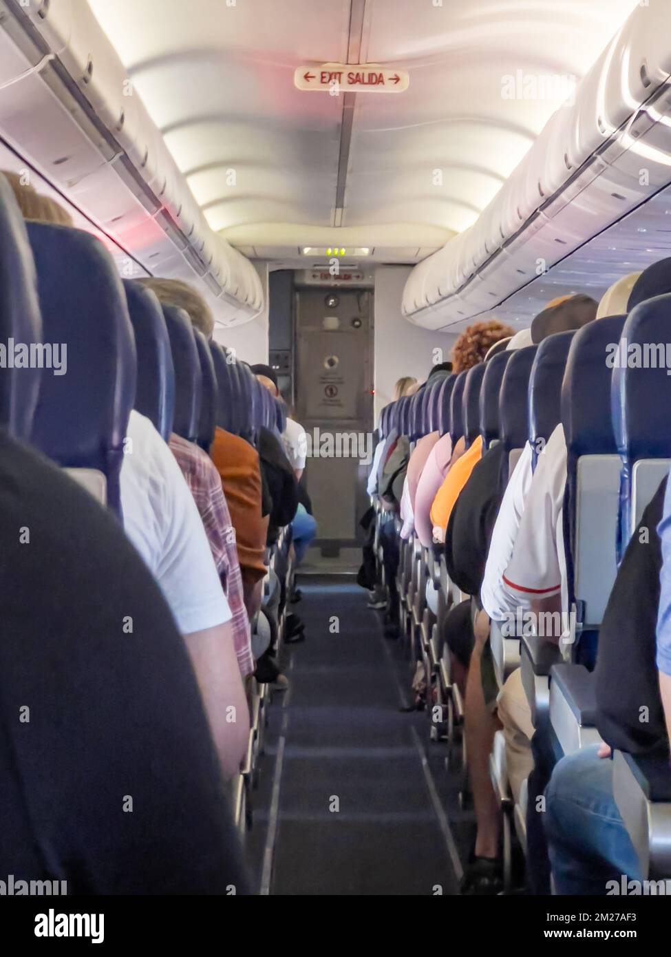 Airplane interior cabin packed full with passengers Stock Photo