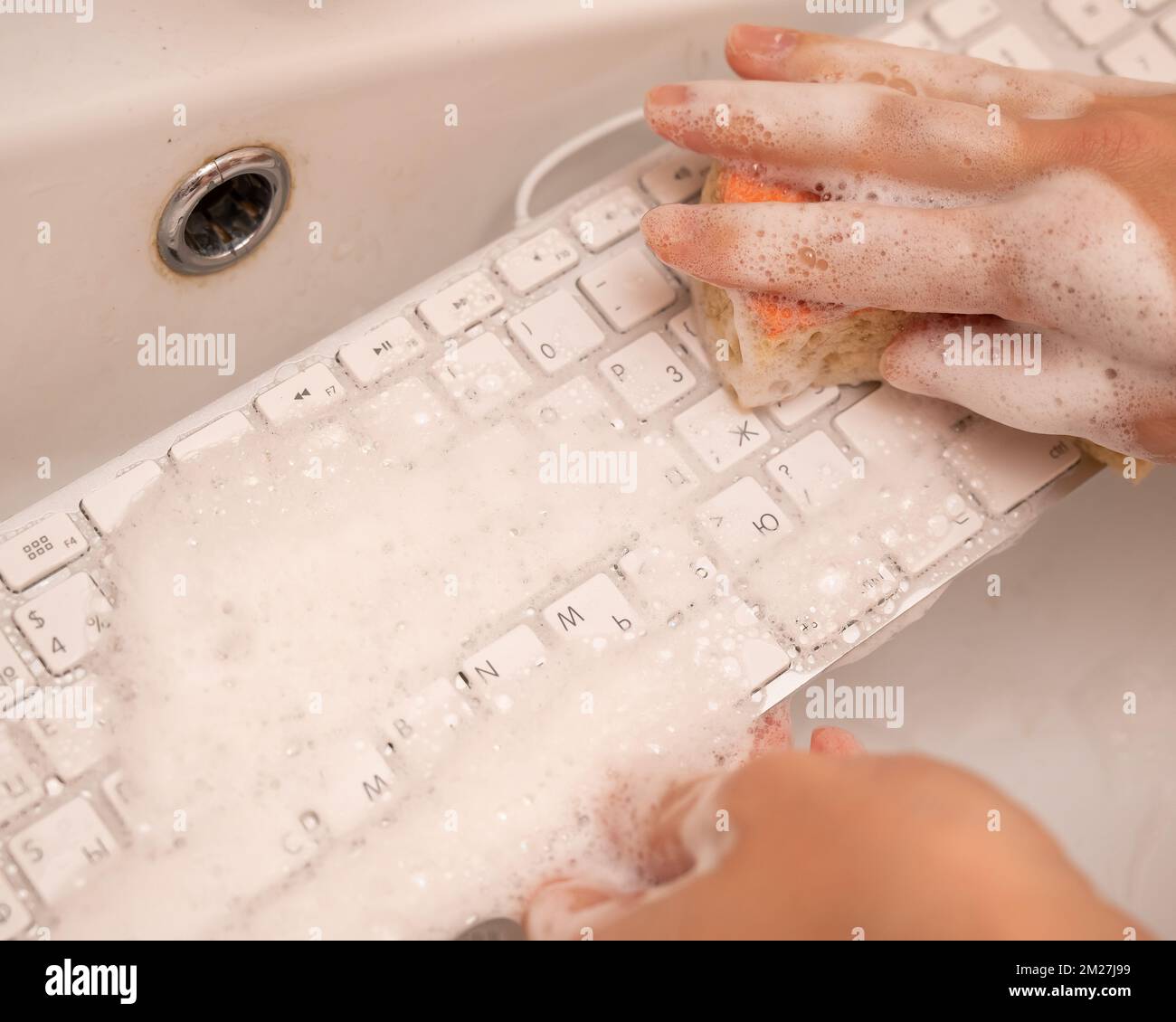 Woman washing white computer keyboard with a sponge with foam Stock Photo Alamy