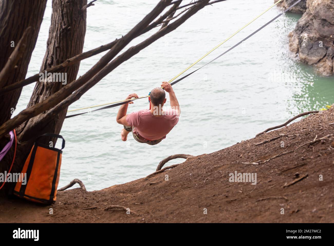 Male slackliner on the rope over a very high cove Stock Photo