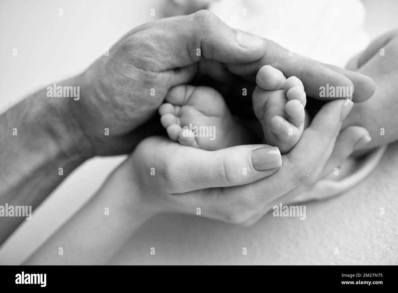 Baby feet in the hands of mother, father, older brother or sister