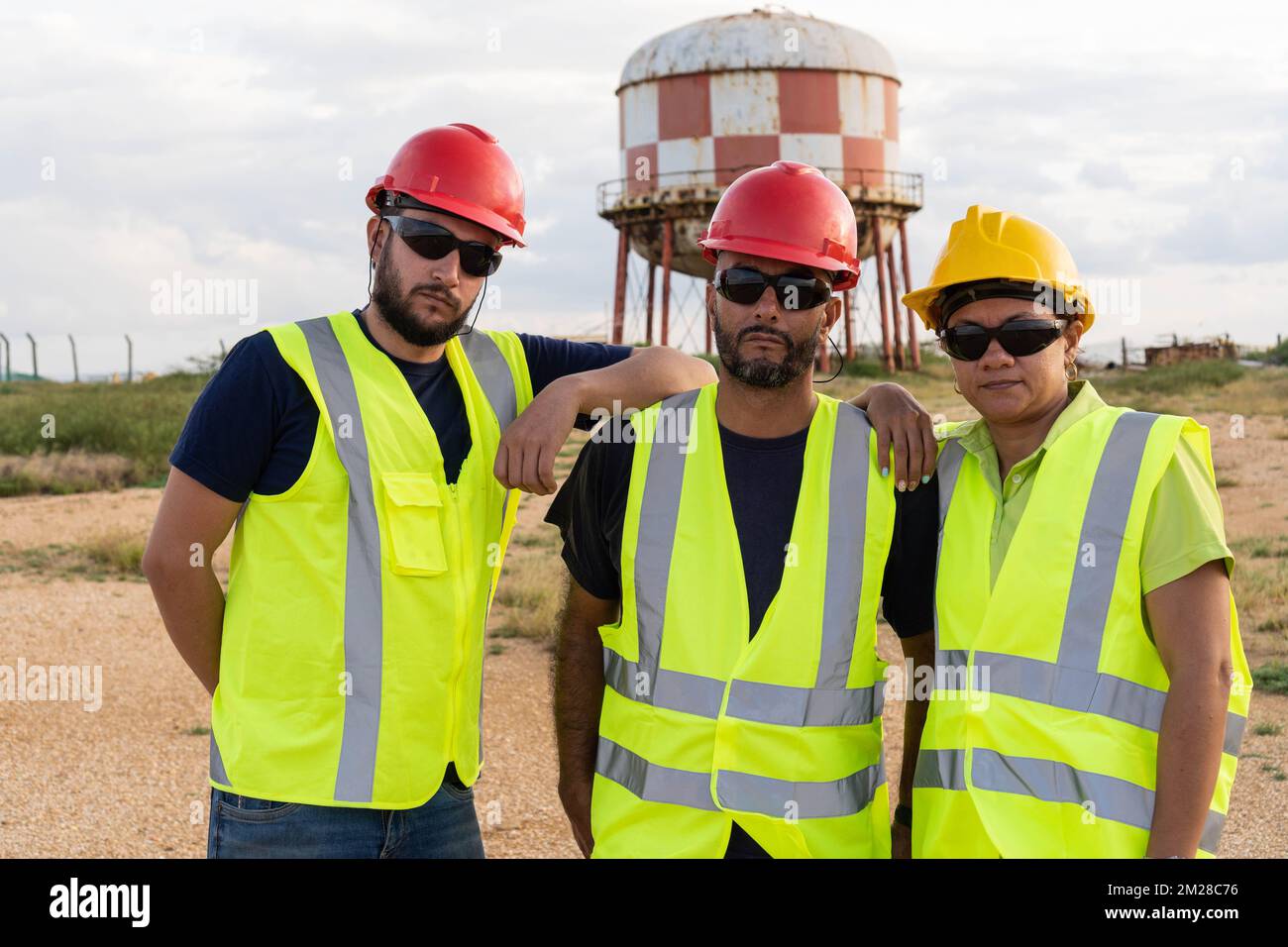 Three workers standing on the construction site Stock Photo