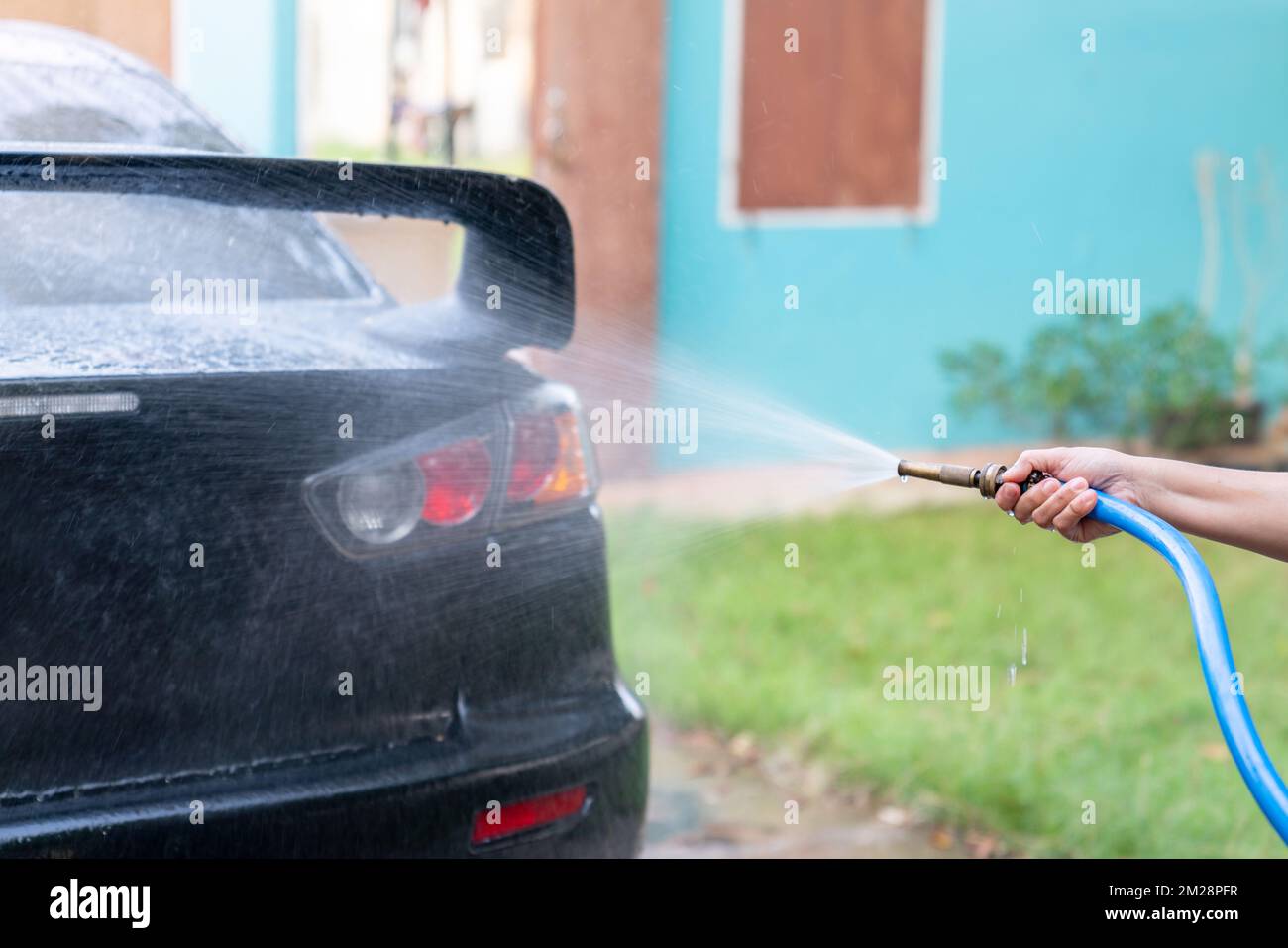 Car wash with a water jet at home. Holiday job. Stock Photo