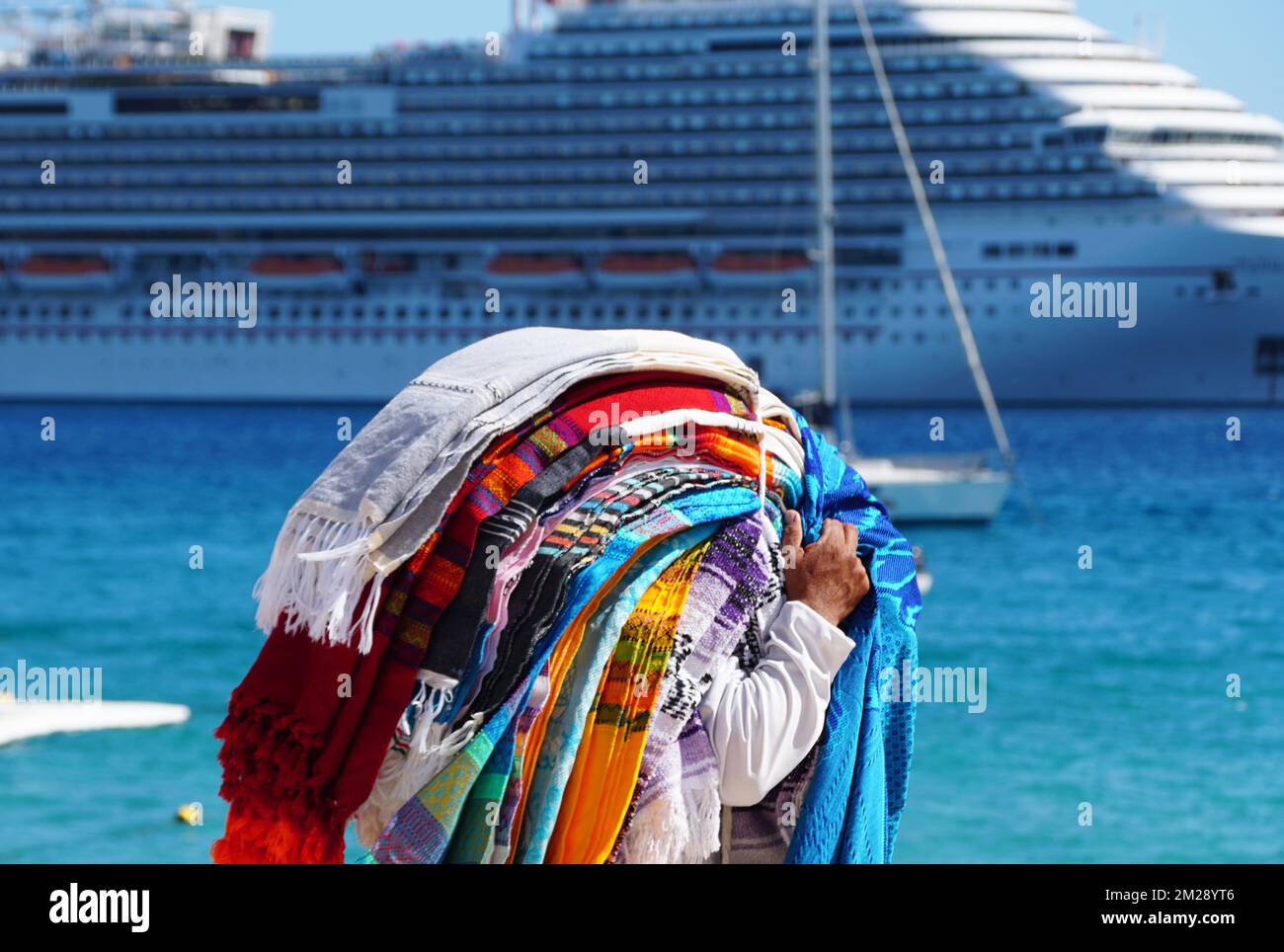 Cabo San Lucas, Mexico - November 7, 2022 - A local salesperson offering colorful blankets for sale on a sunny day Stock Photo