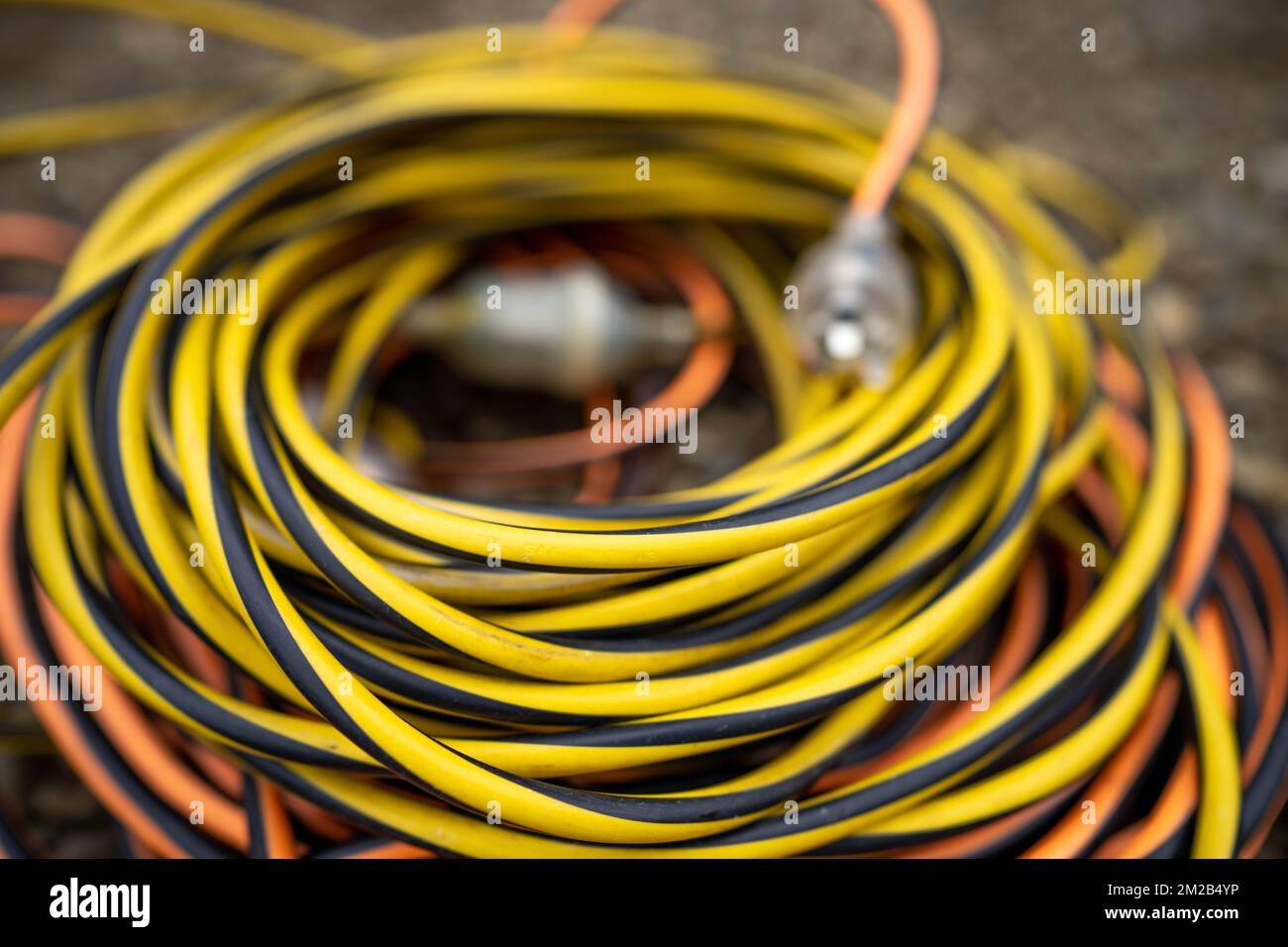 extension cord wrapped up on the ground. extension lead, power lead on a construction site Stock