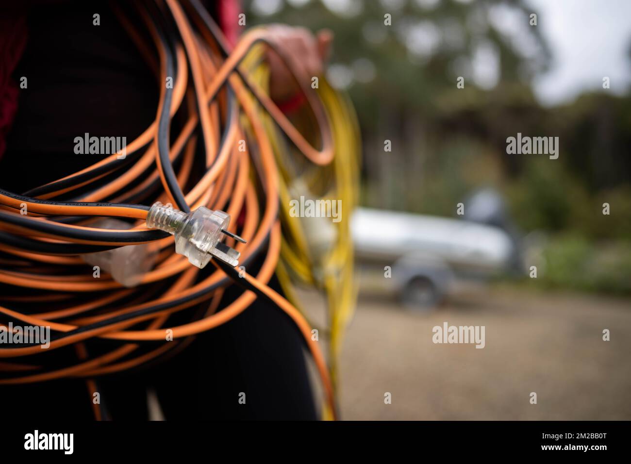 extension cord wrapped up on the ground. extension lead, power lead on