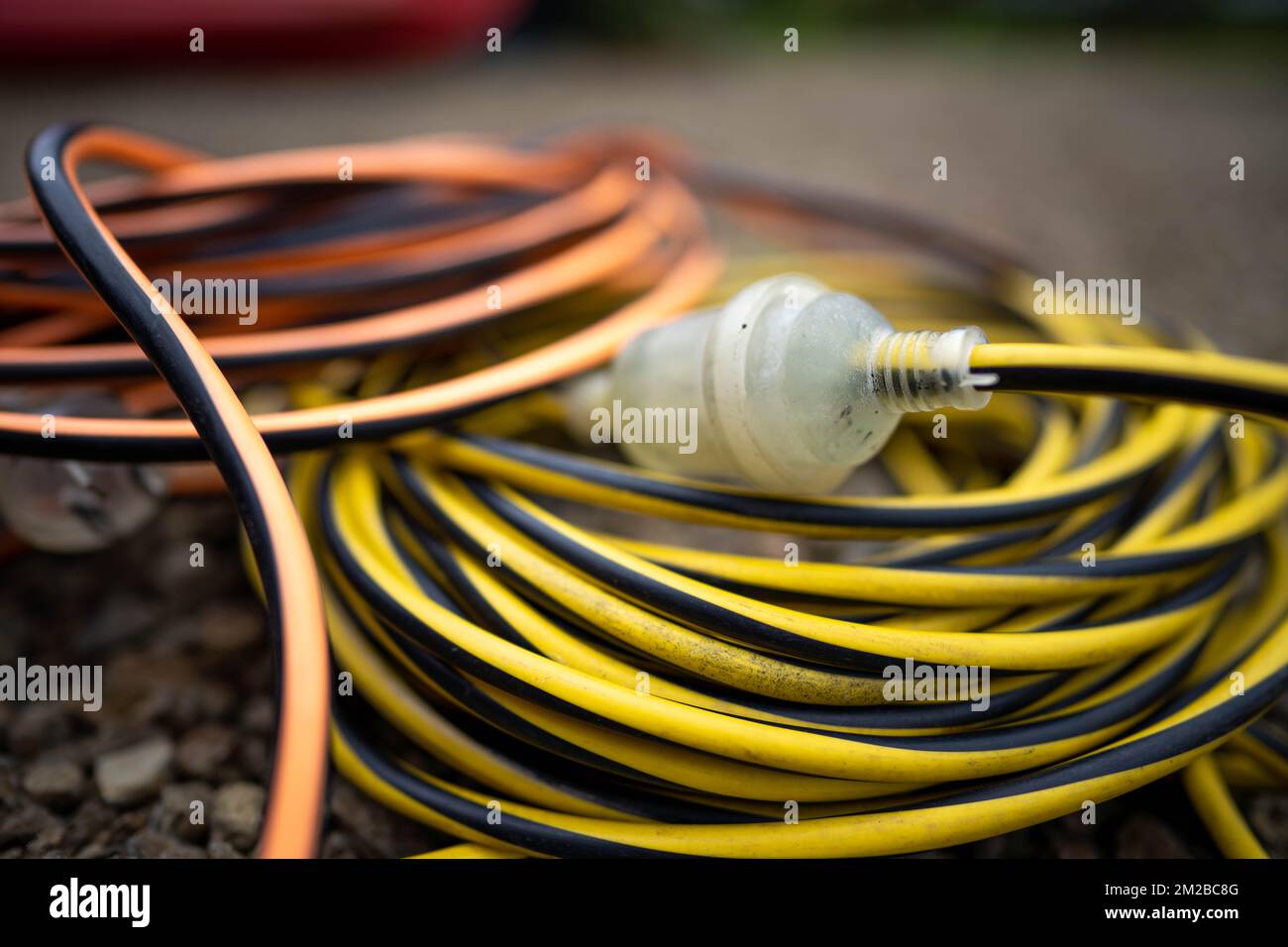 extension cord wrapped up on the ground. extension lead, power lead on