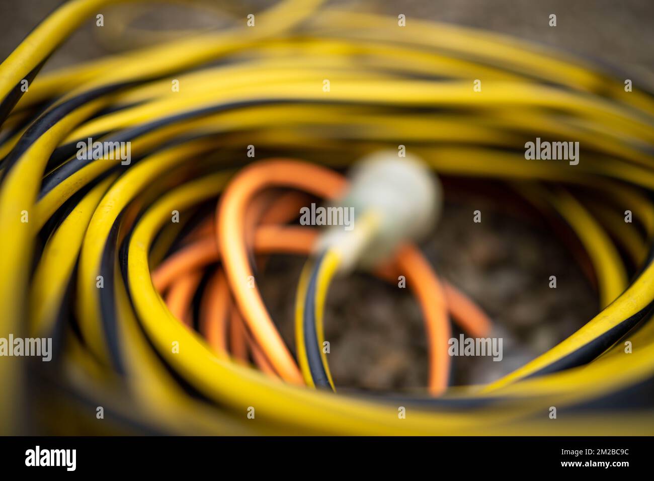 extension cord wrapped up on the ground. extension lead, power lead on a construction site Stock