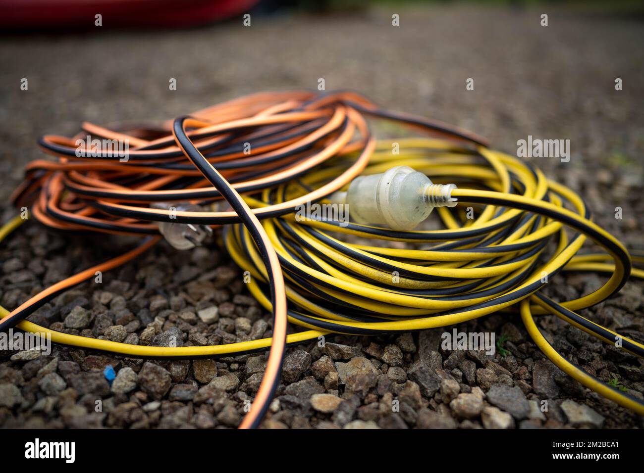 extension cord wrapped up on the ground. extension lead, power lead on