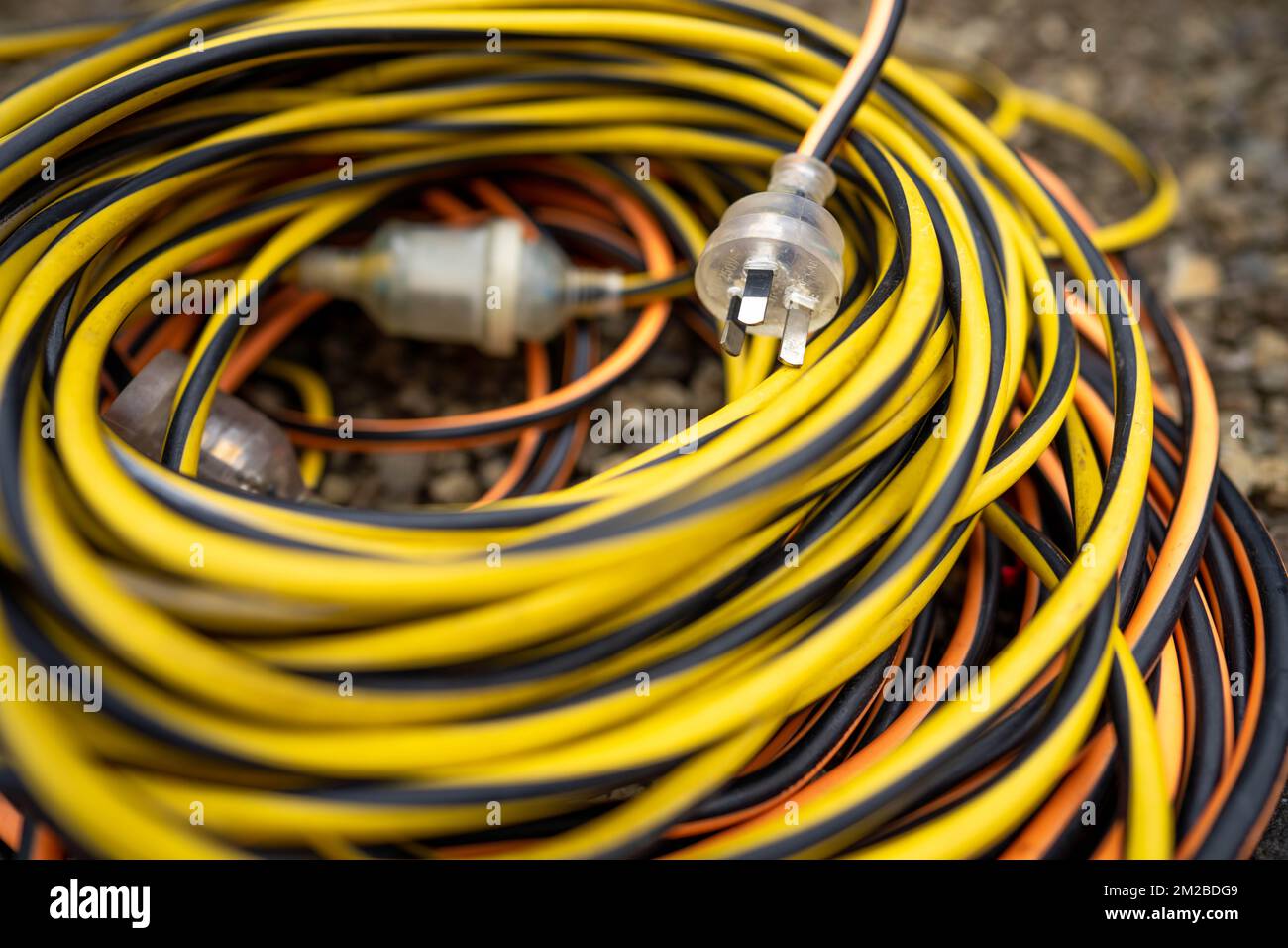 extension cord wrapped up on the ground. extension lead, power lead on a construction site Stock