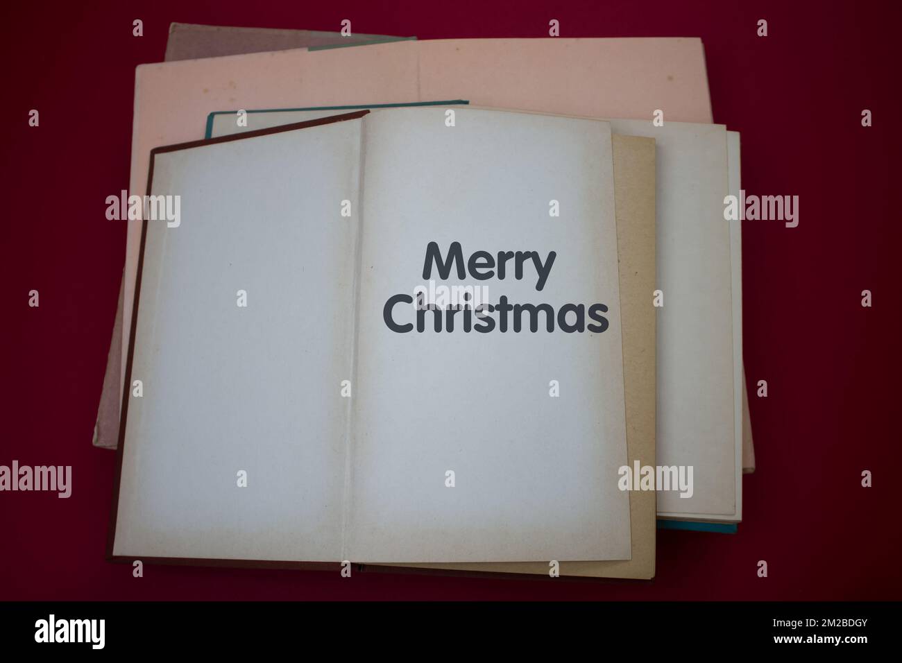 Merry Christmas word in opened book with vintage, natural patterns old antique paper design. Stock Photo