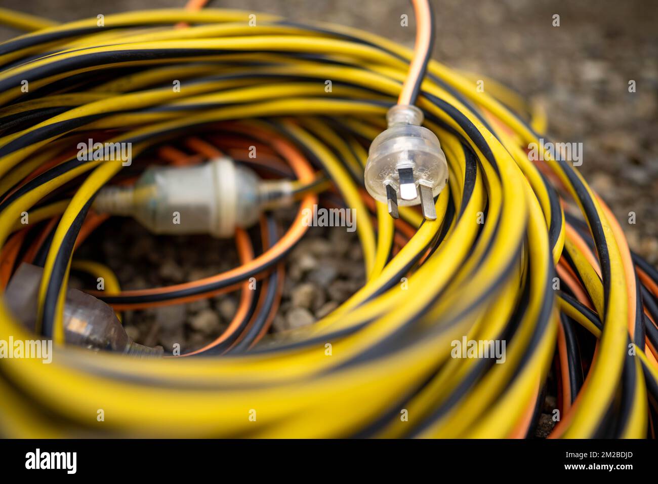 extension cord wrapped up on the ground. extension lead, power lead on