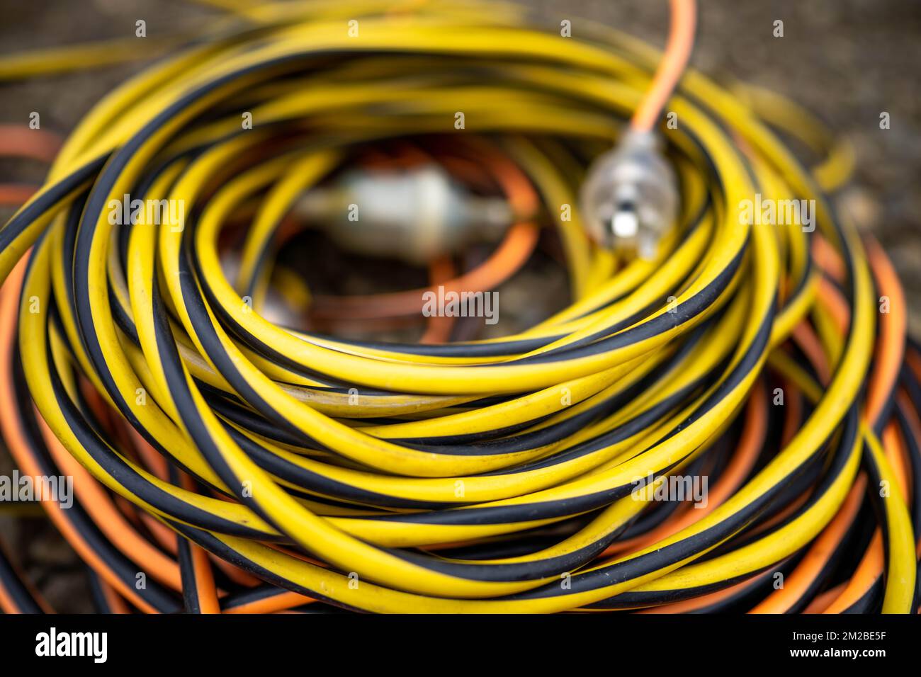extension cord wrapped up on the ground. extension lead, power lead on a construction site Stock