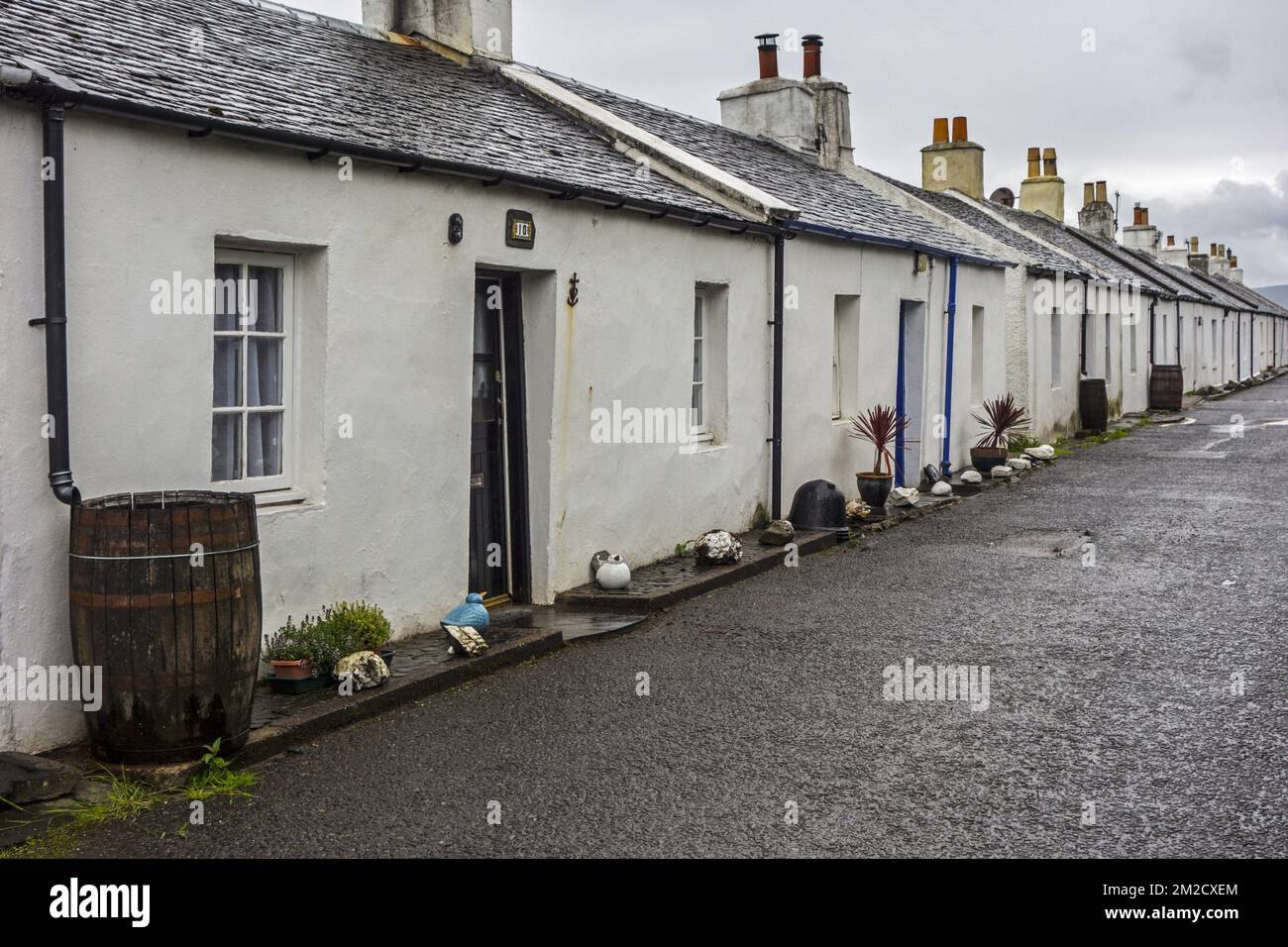 Row of white-harled workers cottages in former slate-mining village Ellenabeich on the isle of Seil, Argyll and Bute, Scotland, UK | Maisons blanches dans le village Ellenabeich sur l'île de Seil, Argyll and Bute, Ecosse, Royaume-Uni 06/06/2017 Stock Photo