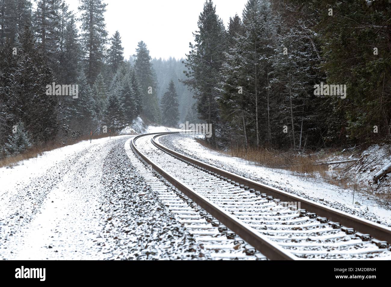 A curved section of BNSF Railroad train tracks in the snow, south of Troy, Montana, on a cold winter morning. Stock Photo
