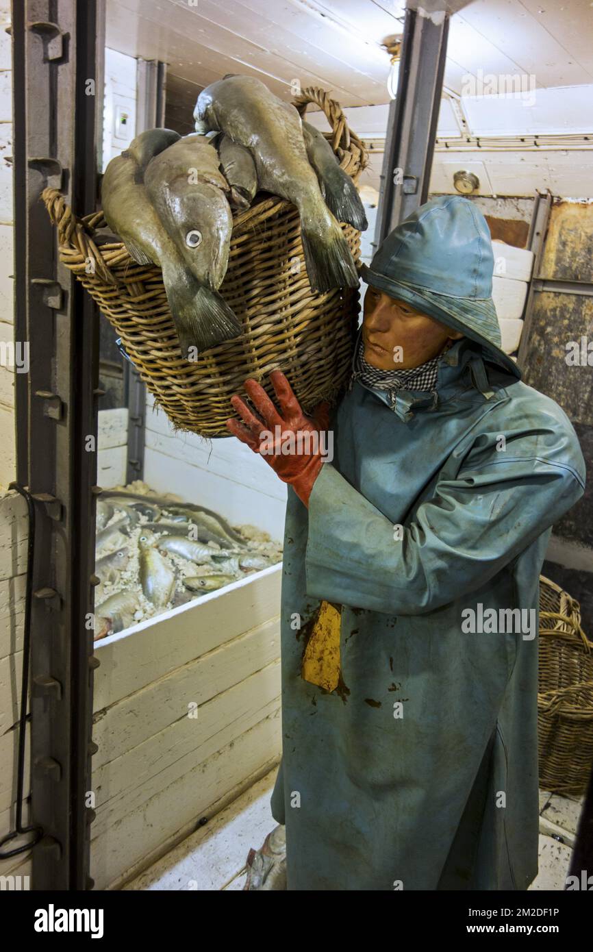 Fisherman wearing Sou'wester in the fish hold of the last Iceland trawler Amandine, renovated fishing boat now serves as museum in Ostend, Belgium | Equipage dans le cale à poisson à bord du chalutier Amandine, maintenant bateau musée à Ostende, Belgique 22/02/2018 Stock Photo