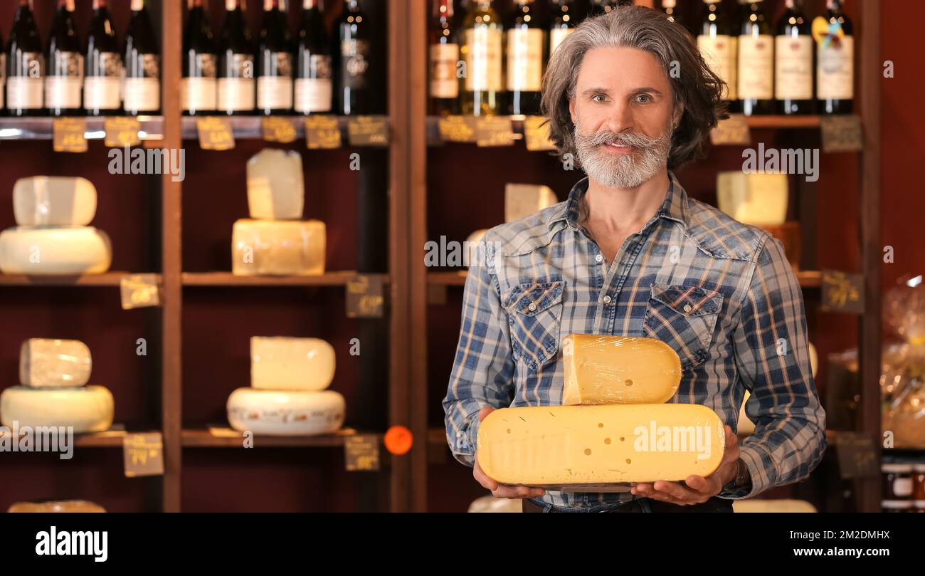Senior business owner with tasty cheese in his store Stock Photo - Alamy