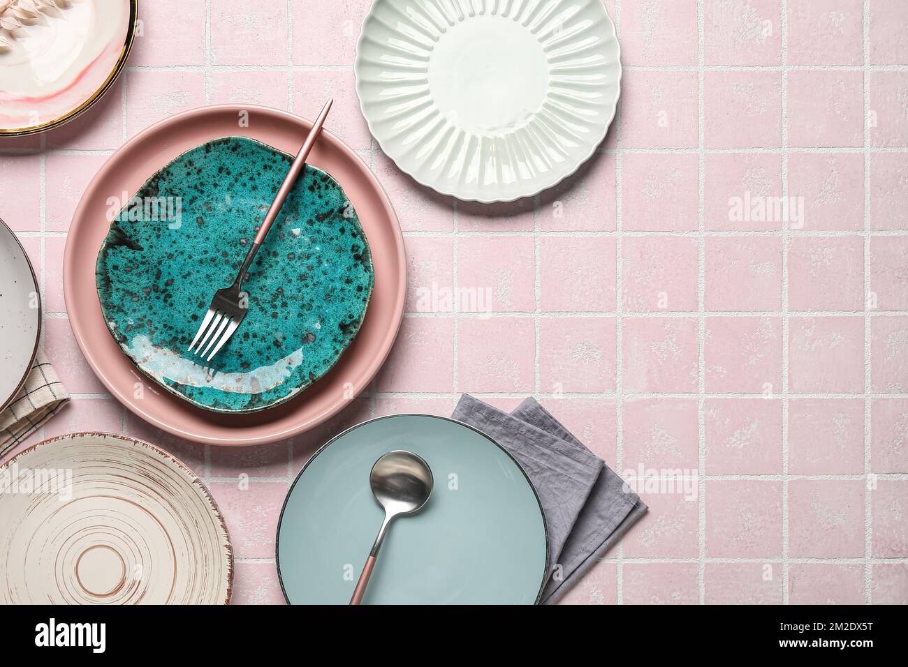Empty plates with cutlery and napkins on pink tile table Stock Photo ...