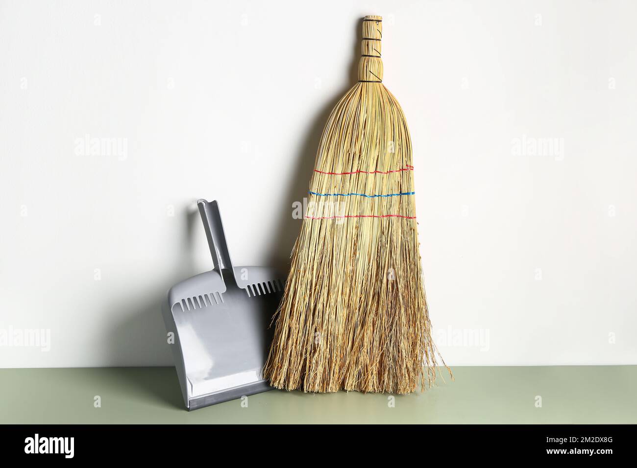 Cleaning broom and dustpan near light wall Stock Photo Alamy