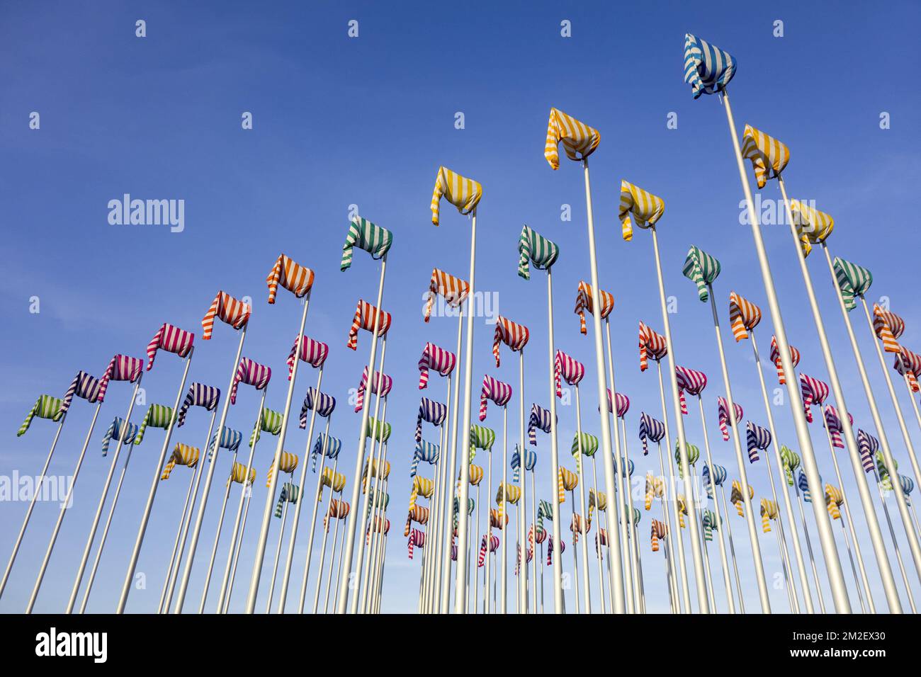 Artwork Le vent souffle où il veut by artist Daniel Buren, hundred flag poles with colorful windsocks at Nieuwpoort / Nieuport, West Flanders, Belgium | Oeuvre d'art Le vent souffle où il veut par l'artiste Daniel Buren à Nieuport, Belgique 18/04/2018 Stock Photo