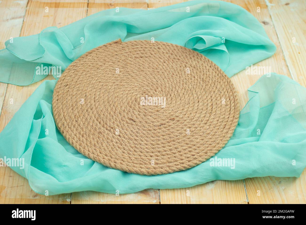 round jute rope placemat on a blue cloth, food photography backdrop