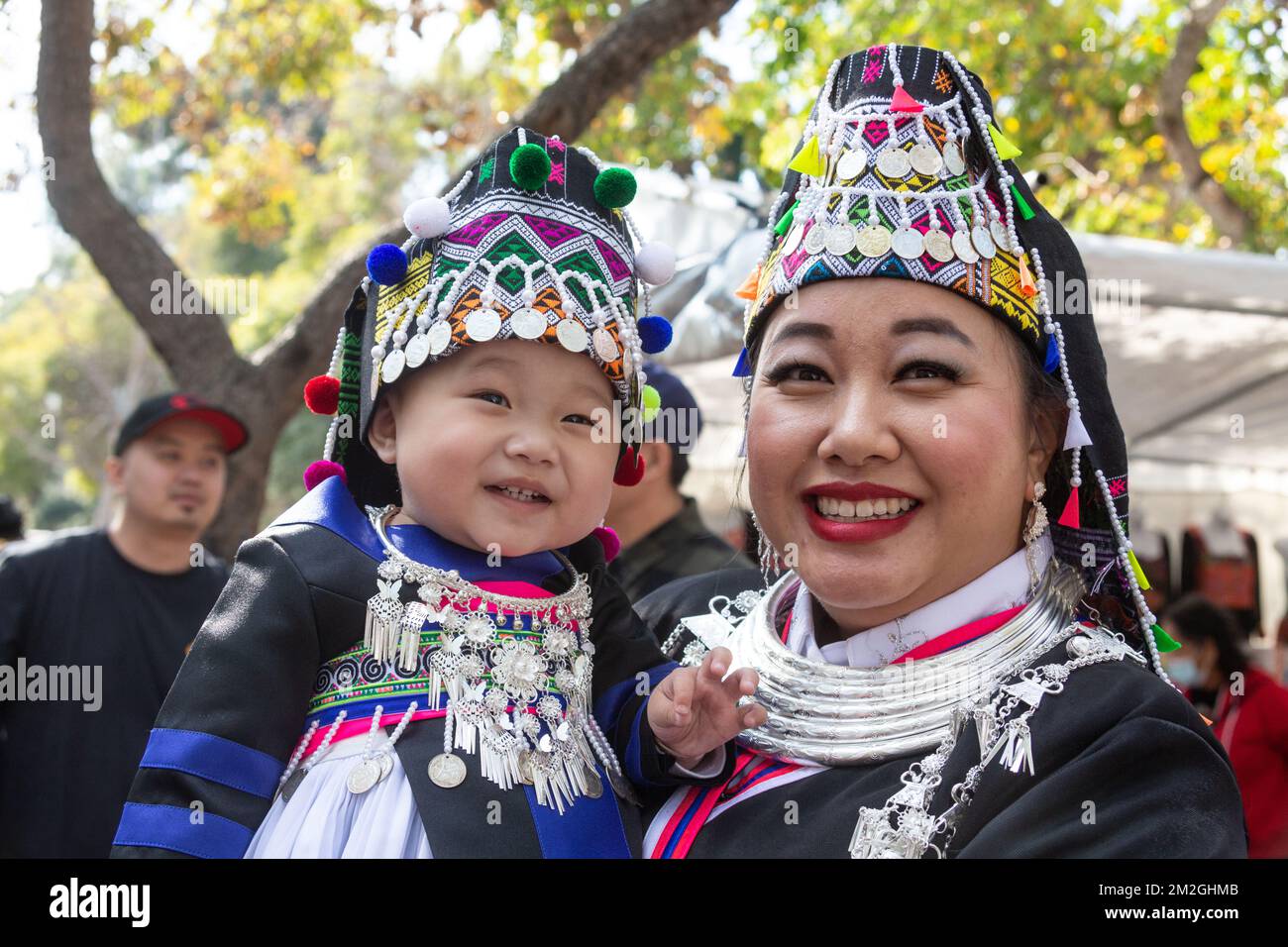 Mother poses with her toddler daughter dressed in traditional attire at