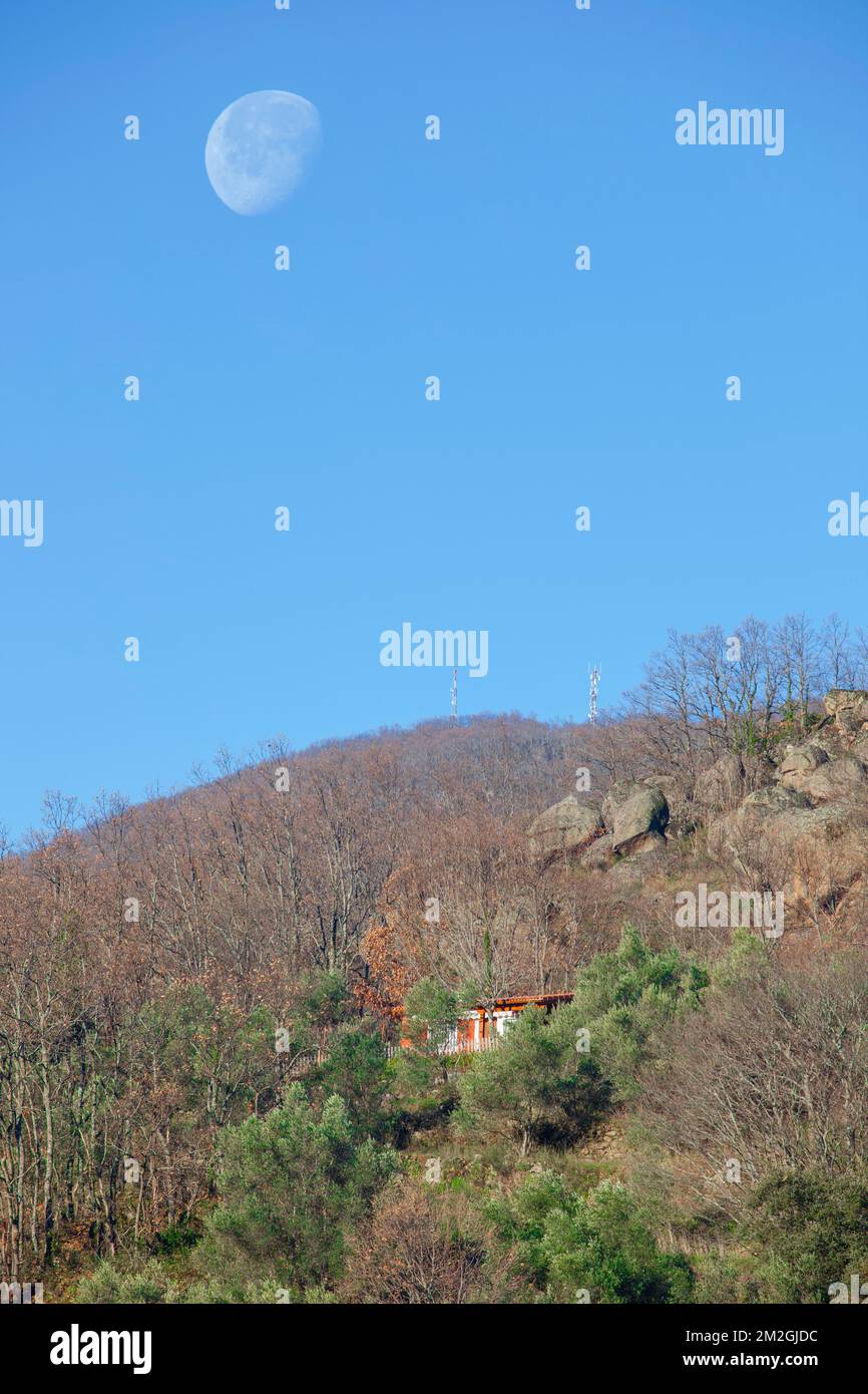 Country house up on the hill with big moon over. Banos de Montemayor, Magic autumn of Ambroz Valley, Extremadura, Spain Stock Photo