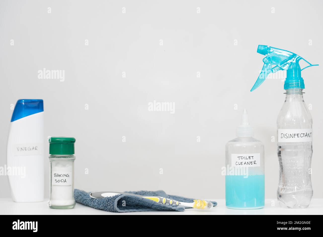 Home cleaning products with labels in reused plastic bottles. Recycled household containers on white background. Horizontal copy space. Reduce concept. Stock Photo