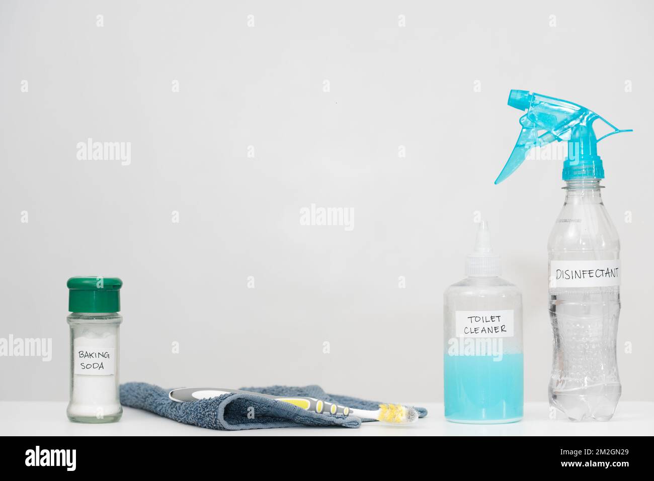 Home cleaning products with labels in reused plastic bottles. Recycled household materials on white background. Horizontal copy space. Reduce concept. Stock Photo