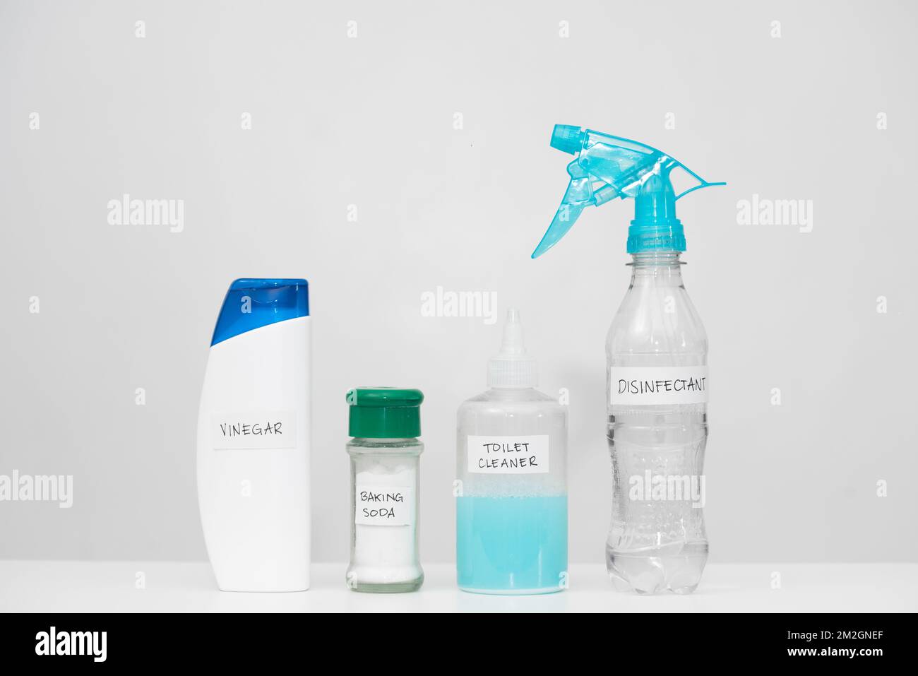 Home cleaning products with labels in reused plastic bottles. Recycled household containers on white background. Horizontal copy space. Reduce concept Stock Photo