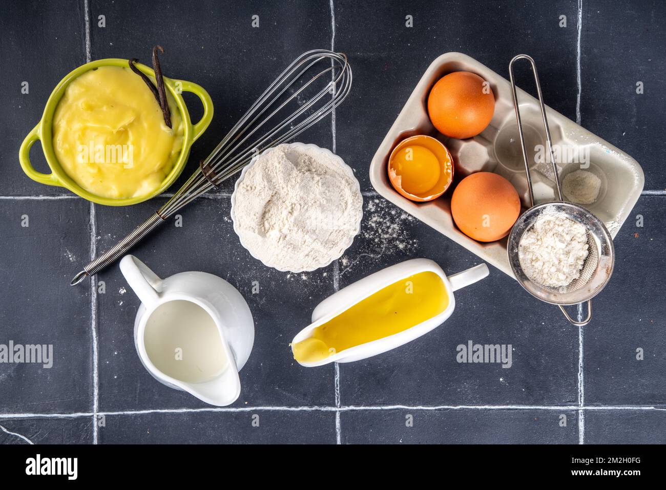 Homemade custard creme with ingredients - vanilla, milk and eggs. Sweet Creme anglaise dessert cooking background, on black kitchen table copy space Stock Photo